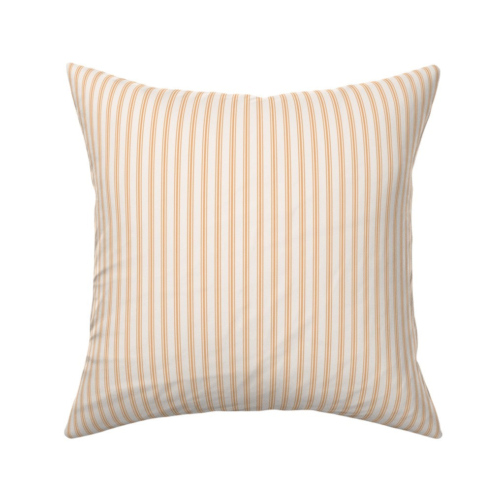 Classic mattress ticking stripe fabric shown on a square pillow. The color of the stripe is orange tangerine on off white.
