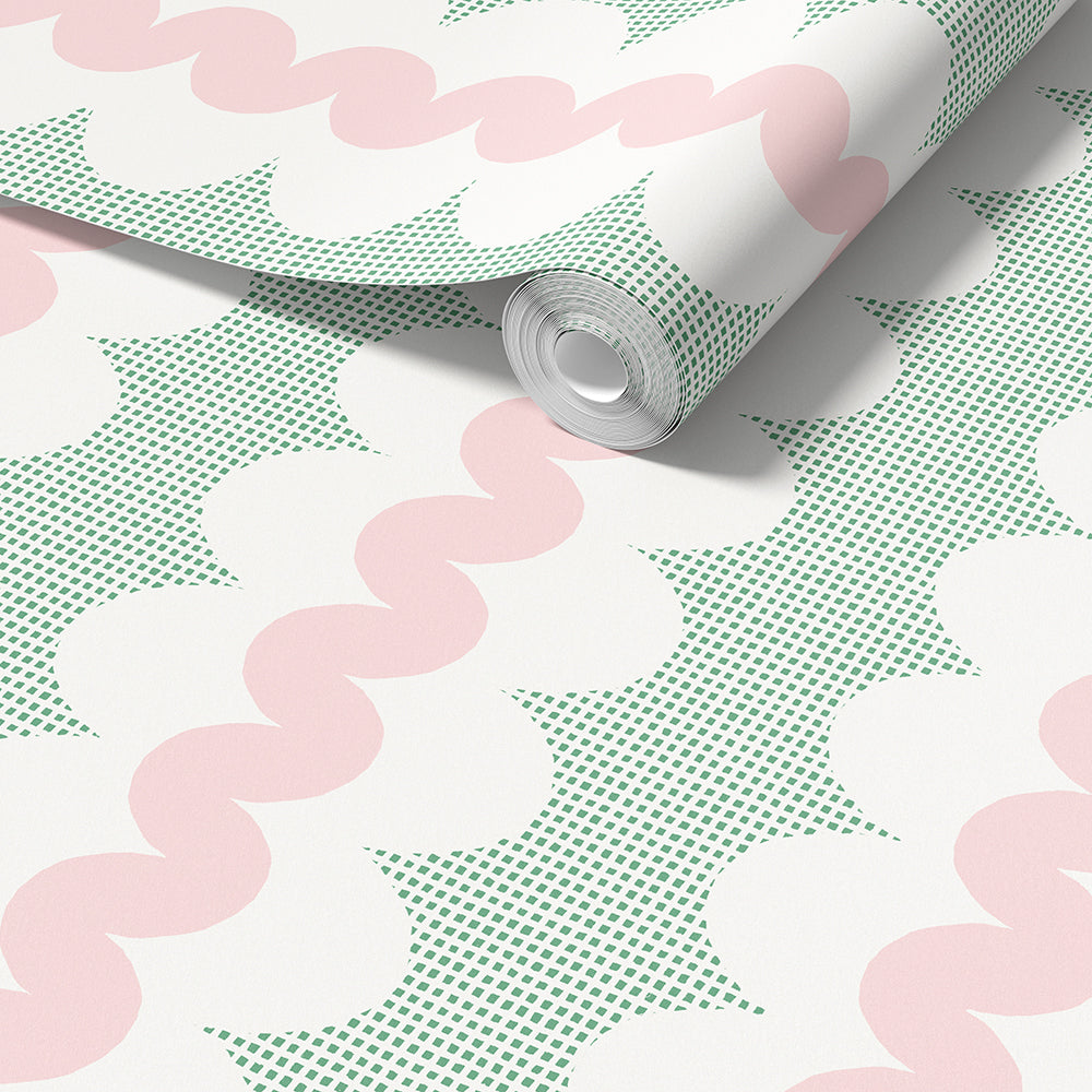 A roll of wallpaper with a retro pattern of pink wavy lines, green square dots and white oval shapes, shown partially unrolled on a white surface.