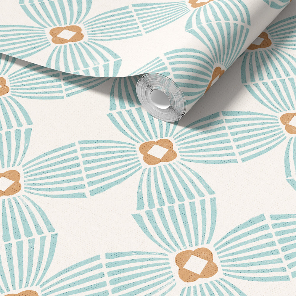 A roll of wallpaper with a repeating mid-century modern fan pattern in light blue and warm tan on an off-white background, shown with the top corner rolled back.