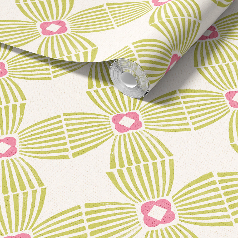 A roll of wallpaper with a repeating geometric pattern in olive green and pink on a warm off-white background, shown partially unrolled.