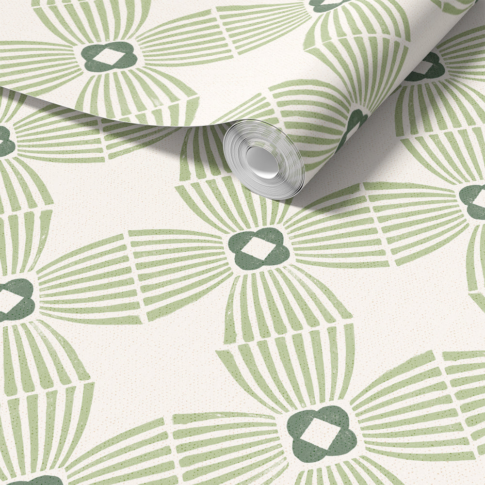A roll of wallpaper with a repeating geometric pattern in sage green and dark green on a warm off-white background, shown partially unrolled.