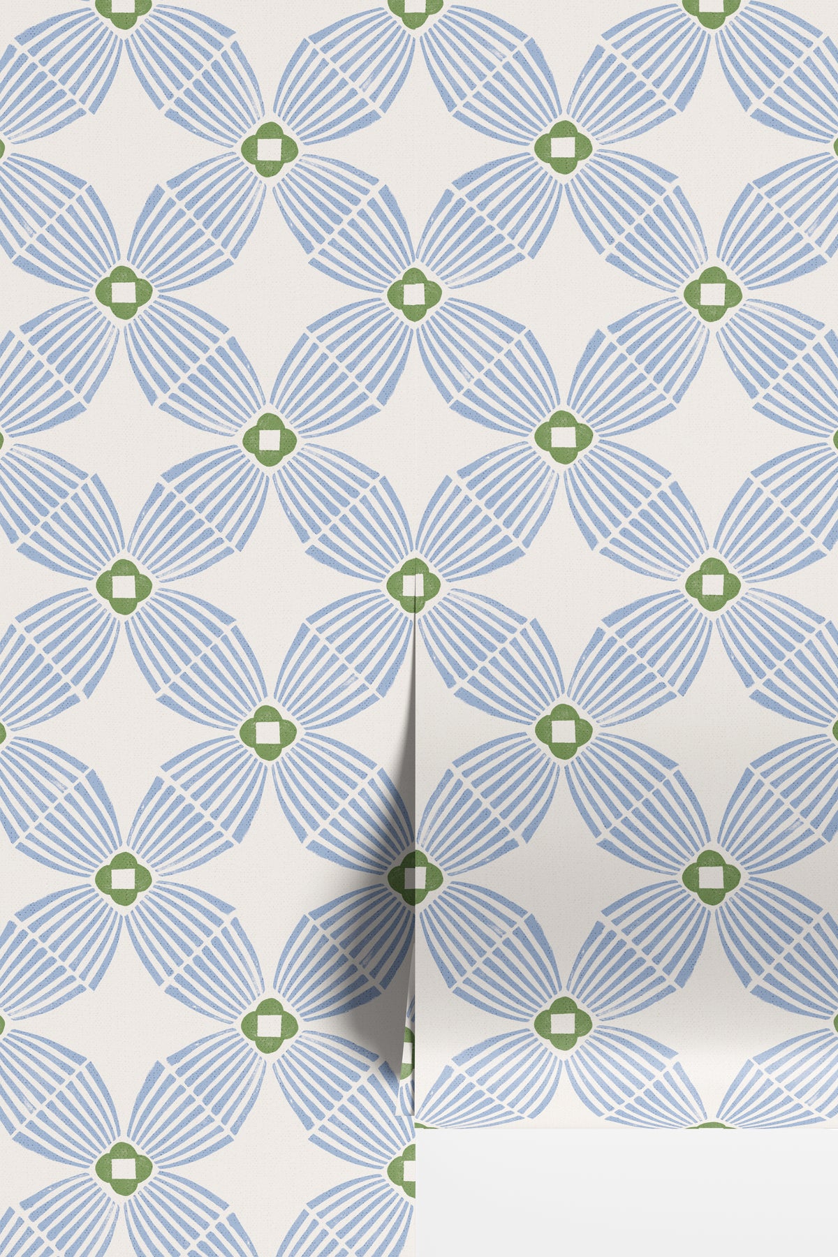A close-up of wallpaper rolls with a repeating geometric pattern of blue and green stylized flowers on an off-white background.