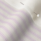 super close up of a lilac ticking stripe fabric with one single pin.