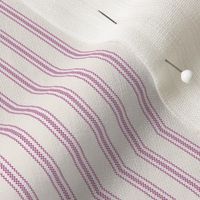 close up of mattress ticking stripe fabric in magenta on off white