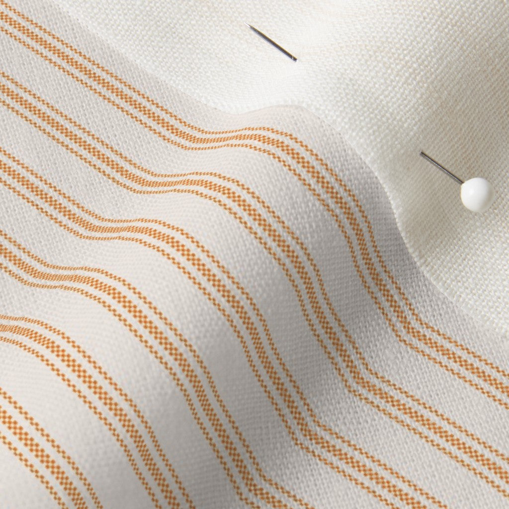close up of mattress ticking stripe fabric in orange tangerine on off white