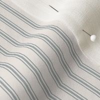 close up of mattress ticking stripe fabric in stormy gray on off white
