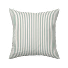 Classic mattress ticking stripe fabric shown on a square pillow. The color of the stripe is british racing green on off white.