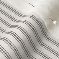 close up of mattress ticking stripe fabric in charcoal black on off white
