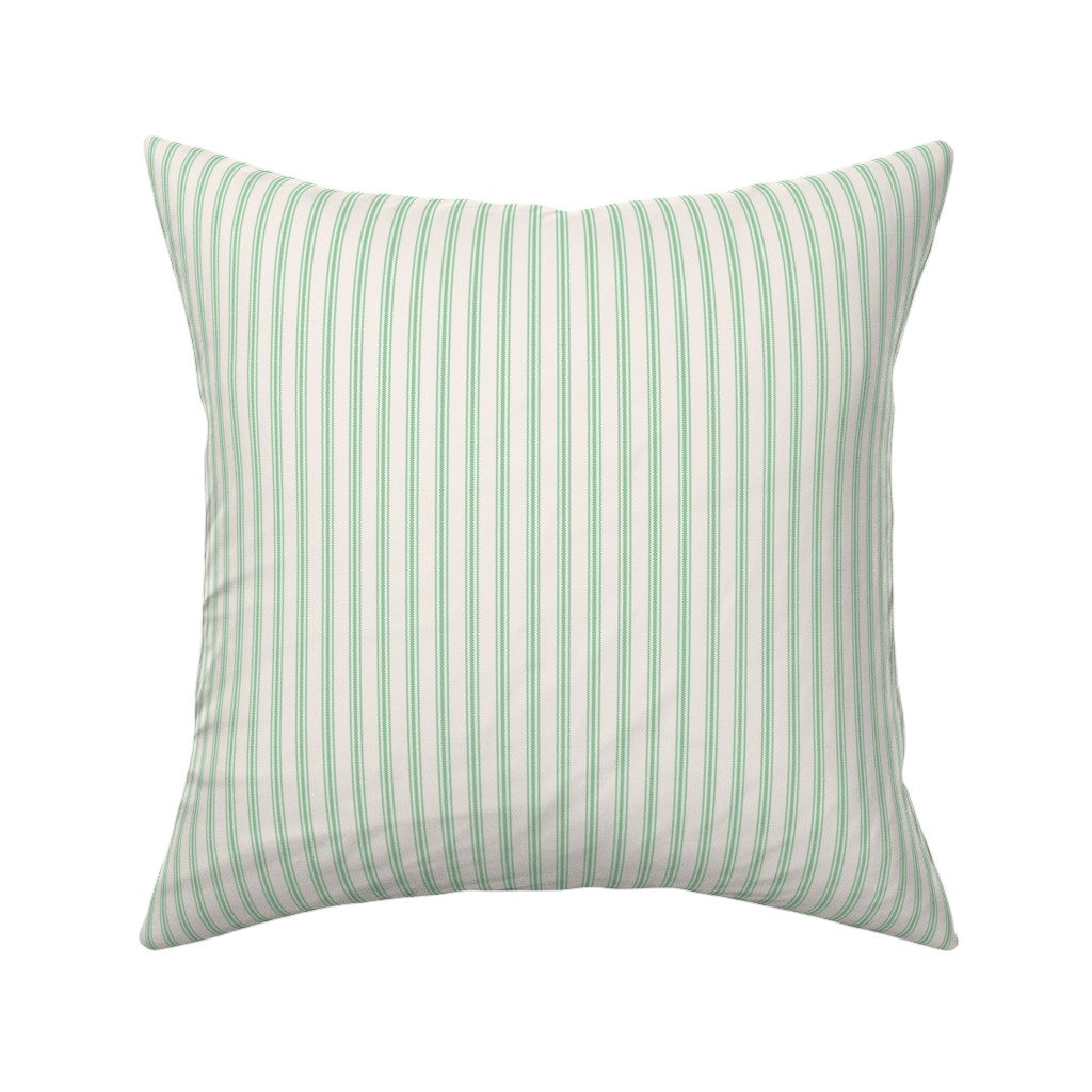 Classic mattress ticking stripe fabric shown on a square pillow. The color of the stripe is kelly green on off white.
