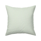 Classic mattress ticking stripe fabric shown on a square pillow. The color of the stripe is kelly green on off white.