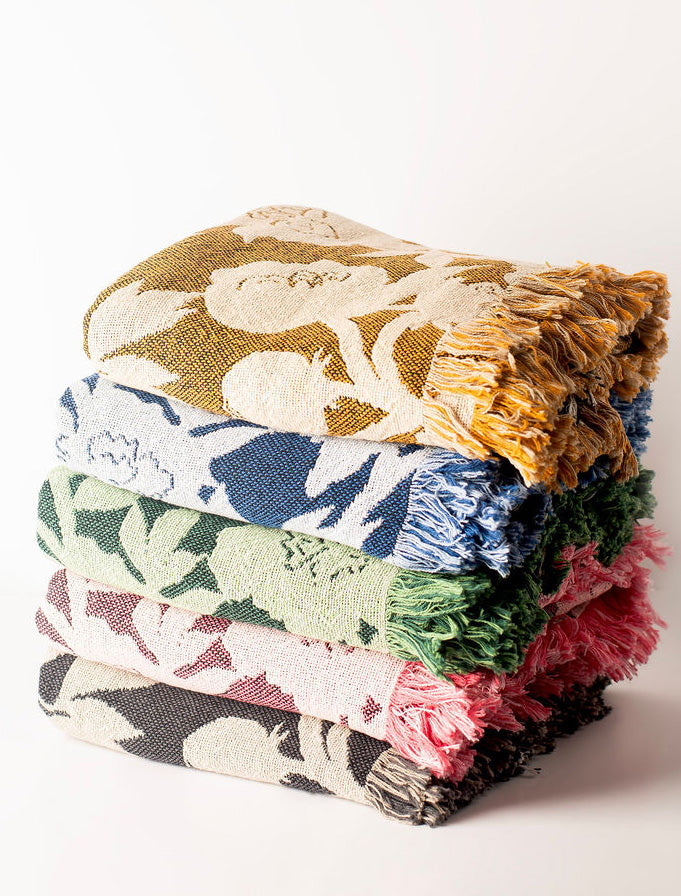 Stack of colorful patterned blankets on a white background