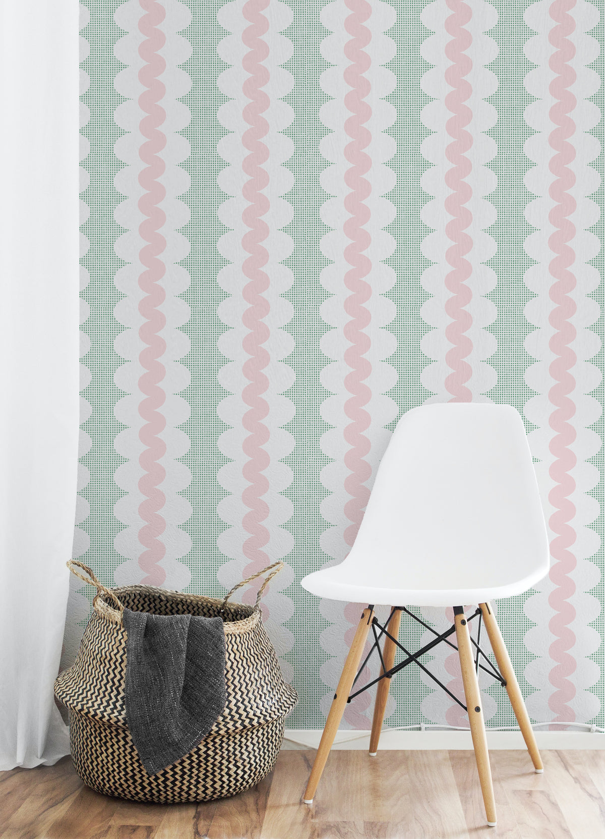 A styled interior corner showing a pale mint green wallpaper with vertical wavy stripes in white and soft pink, a white molded side chair with wooden legs, a woven basket, and a light wood floor.