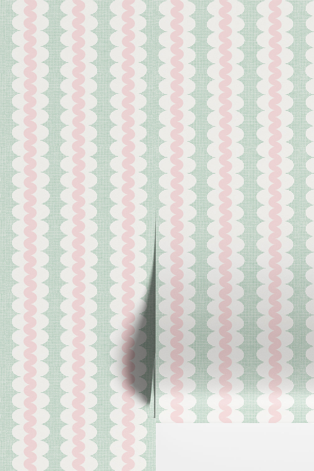 Striped wallpaper with a curvy stripe in soft pastel pink, on a stripe of white oval shapes, with a green square grid in the background. Shown as two wallpaper rolls on a wall.