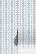 Light blue and white patterned wallpaper with vertical wavy stripes and a subtle grid texture, shown partially rolled to reveal a white backing layer.