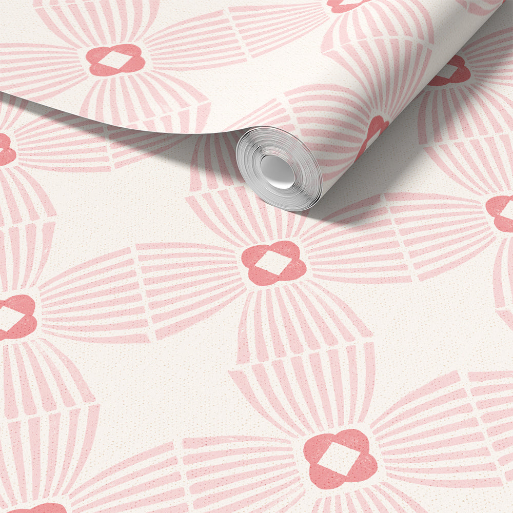 A roll of wallpaper with a repeating pink and white geometric fan pattern, partially unrolled to show the texture and design.