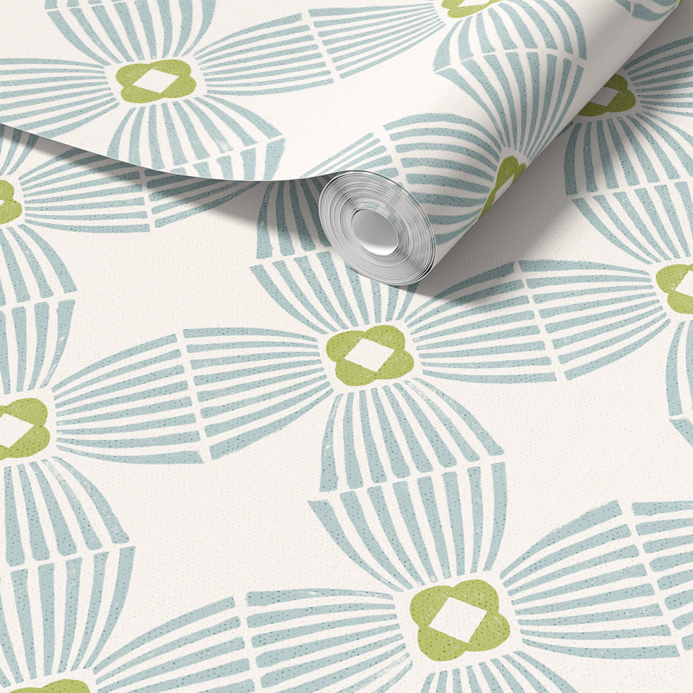 A roll of wallpaper with a repeating geometric pattern in light blue and olive green on an off-white background, shown partially unrolled.