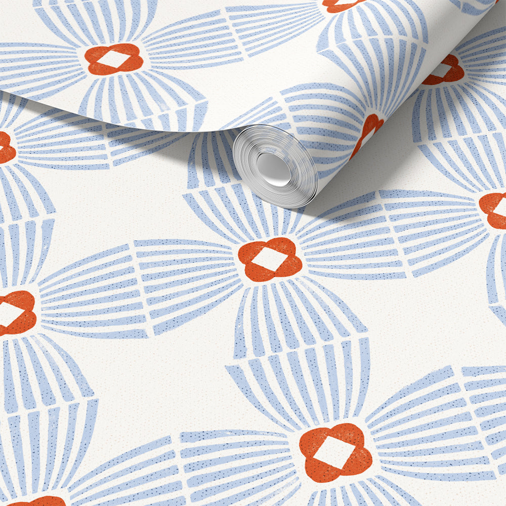 A roll of wallpaper with a repeating mid-century modern pattern featuring light blue striped fan shapes and orange flower-like centers on an off-white background.