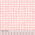 Gingham plaid patterned fabric in coral pink and off white. There is an inch scale overlaid at the bottom for visual reference.