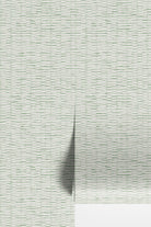 A close-up of a light gray and white textured material with a fine horizontal pattern, showing a vertical fold that casts a soft shadow.
