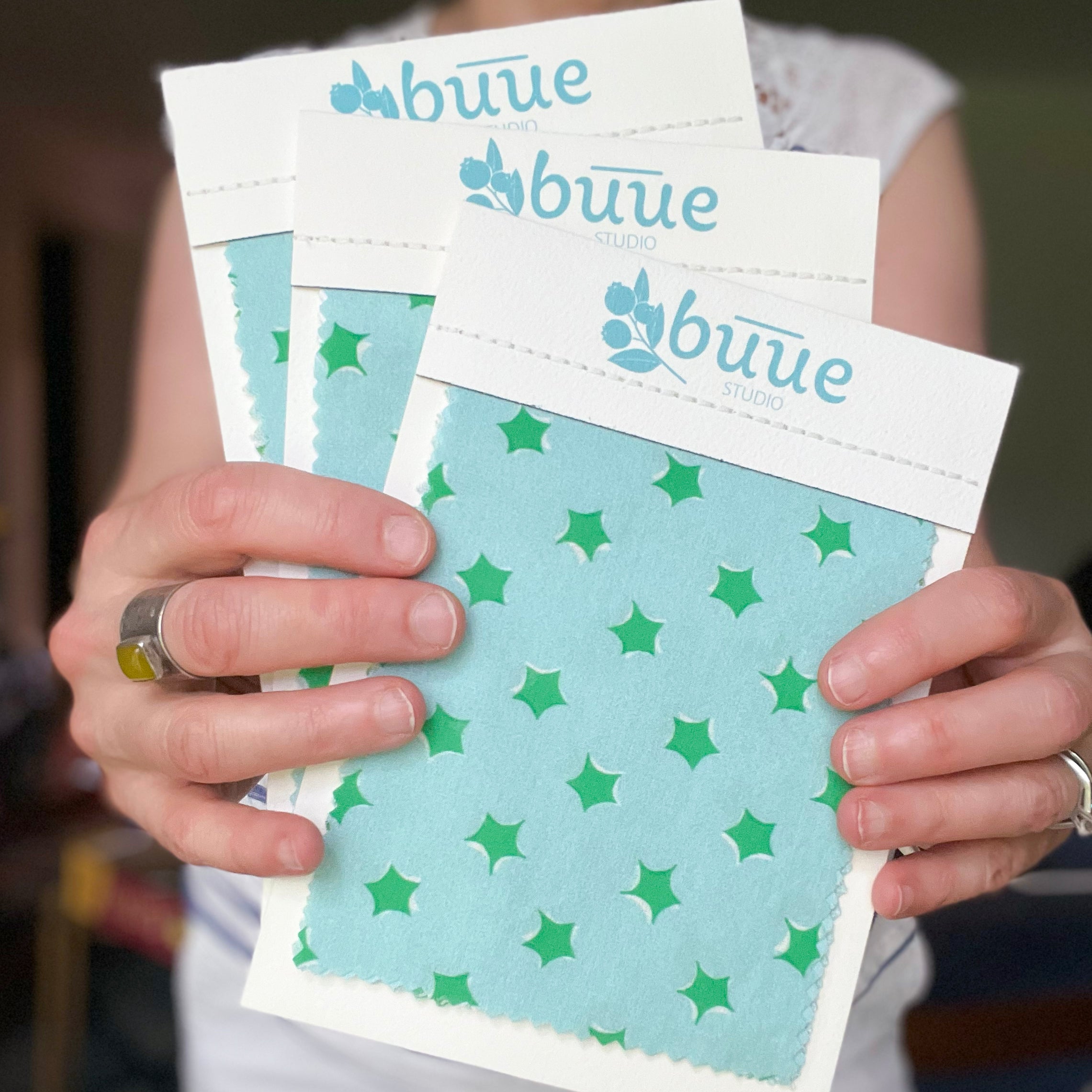 Hands holding packages of buue fabric memos with star pattern
