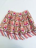 A short pleated skirt with a retro floral print in orange, pink, and brown, featuring a striped coordinated hem, laid flat on a white background.