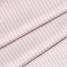 A close-up of a lilac-colored fabric with a classic ticking stripe pattern. 