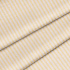 Close up of a yellow mattress ticking stripe. The fabric is folded onto itself.